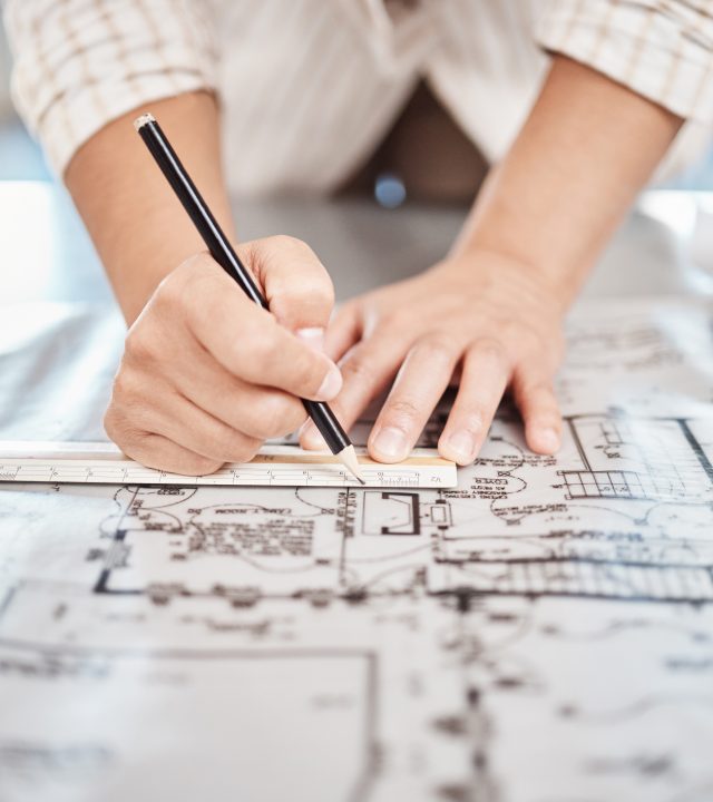 Architect drawing building floor plan, design blueprint map and engineer drafting structure on table paper. Real estate development work, house office construction and industrial wall safety ruler